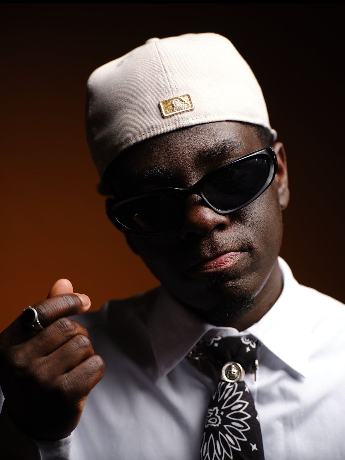 Prince Kofi Nkrumah , a young dark boy with black short hair. Wearing a cap and a white with a black banana at the color.