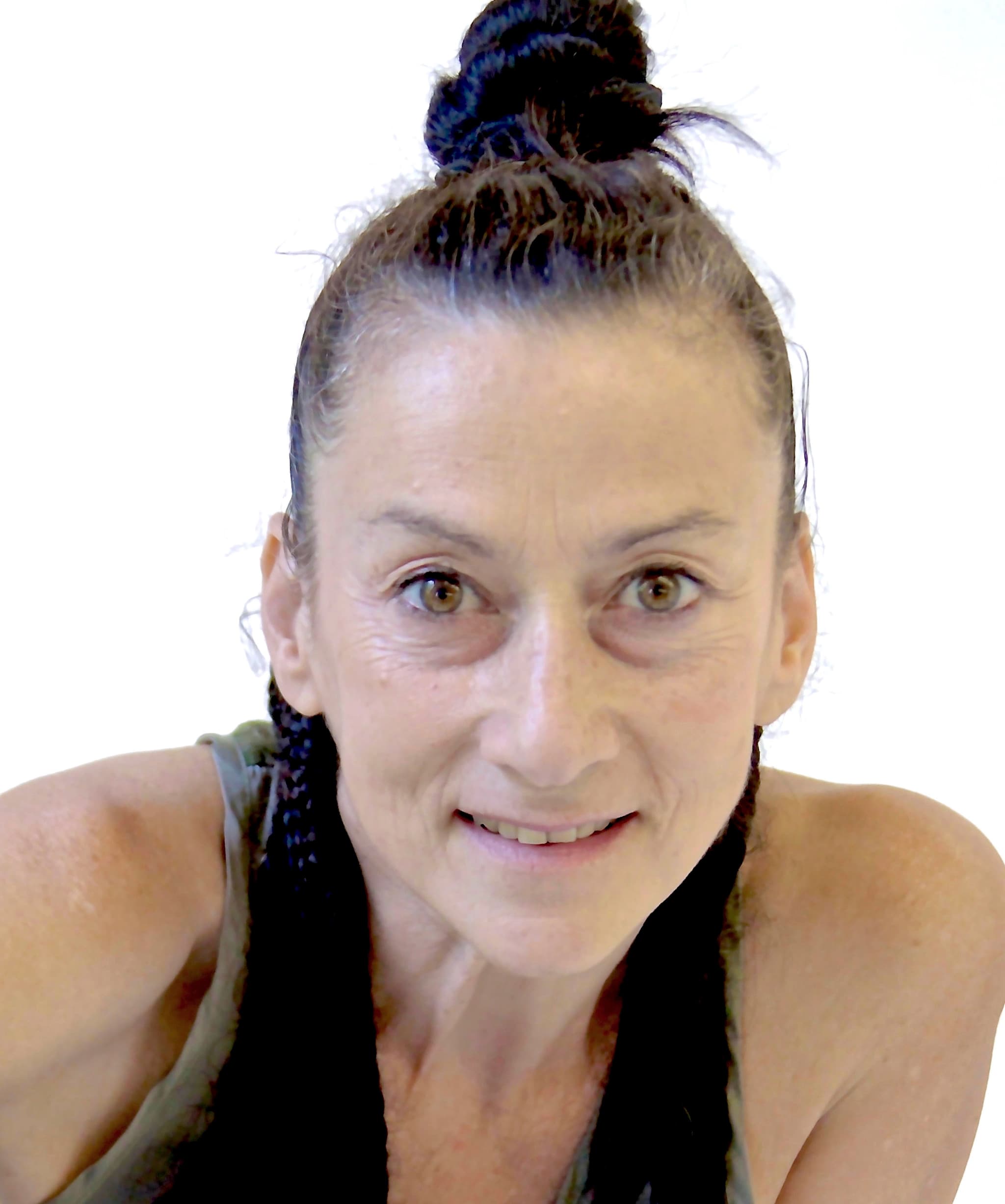 Lina Cruz in a close-up headshot, her hair is up in a bun, we see her face and shoulders, she is wearing a silky top, smiling and looking directly at the camera.